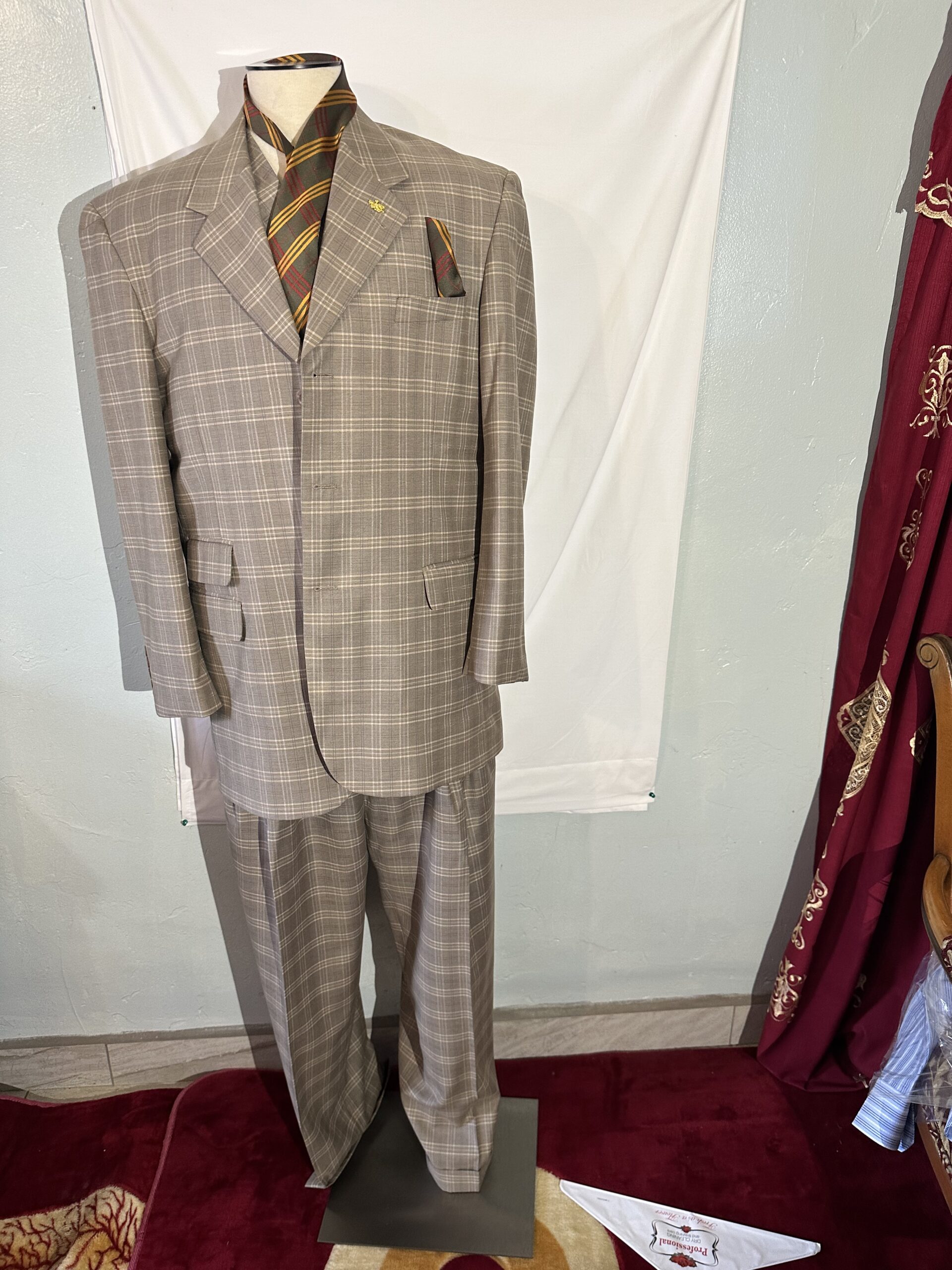 A sports suit on a mannequin in front of a curtain.