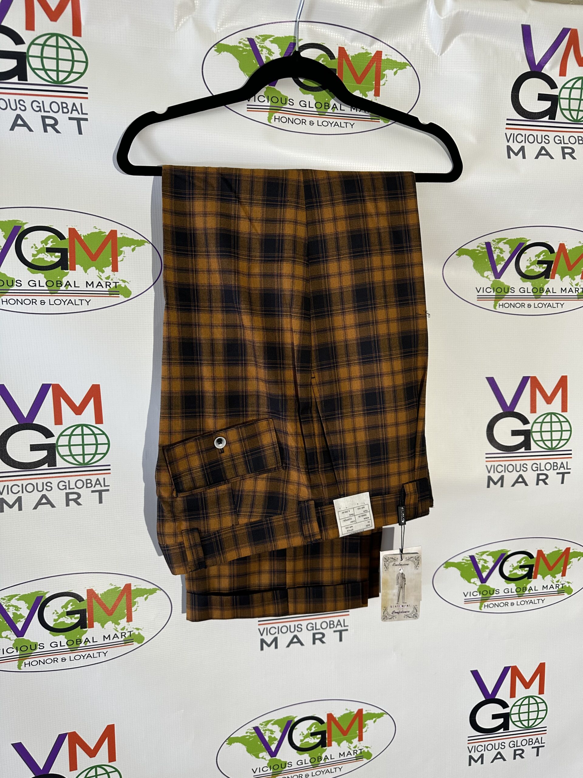 A brown and black Exclusive Yellow Checkered Dress Pants hanging on a hanger.